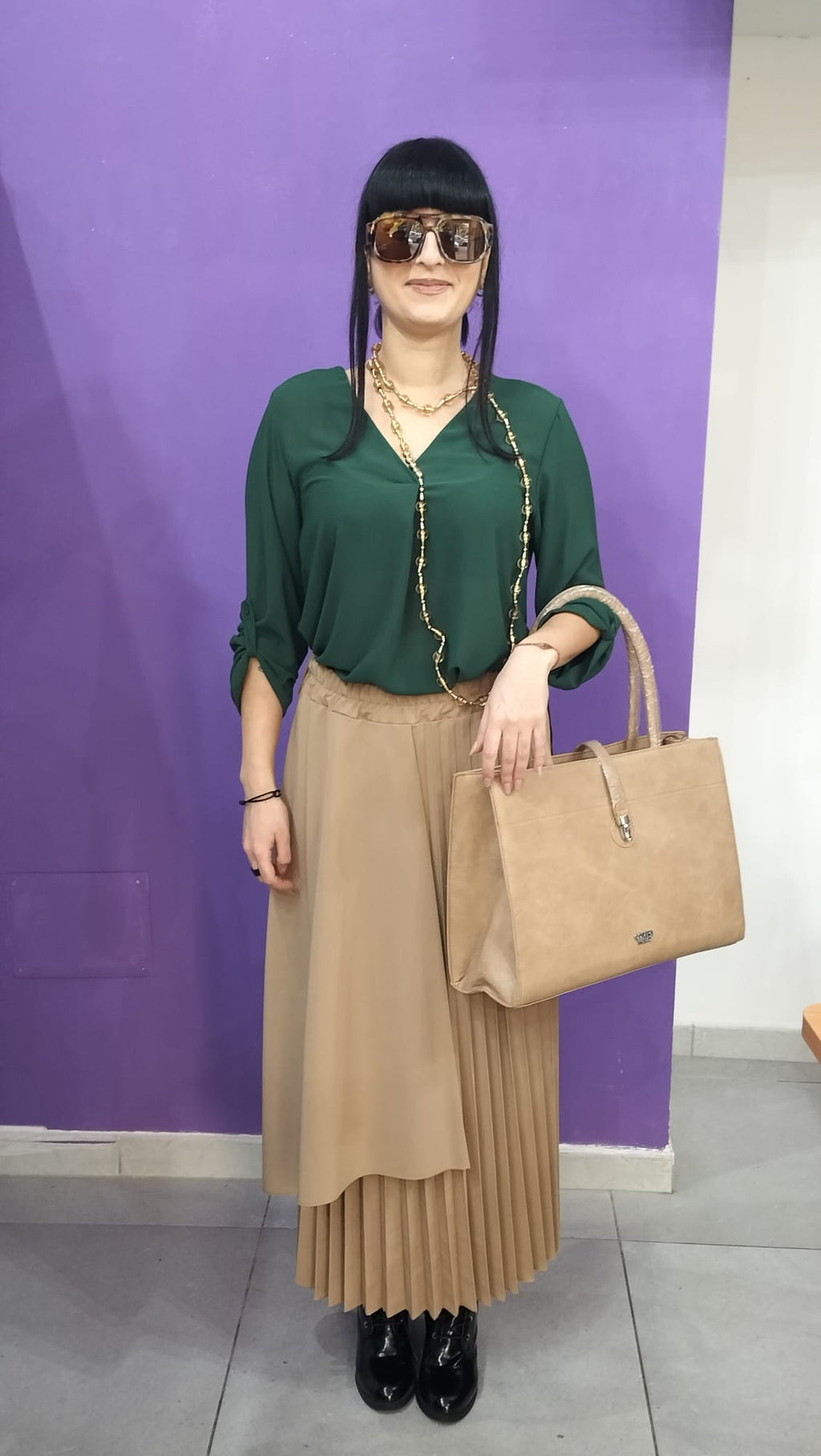 Gonna  Midi Plissettata, con silhouette asimmetrica a doppio strato che crea movimento e profondità visiva.