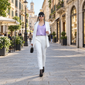 Outfit bianco e lilla a figura intera in una strada del centro