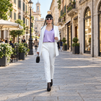 Outfit bianco e lilla a figura intera in una strada del centro